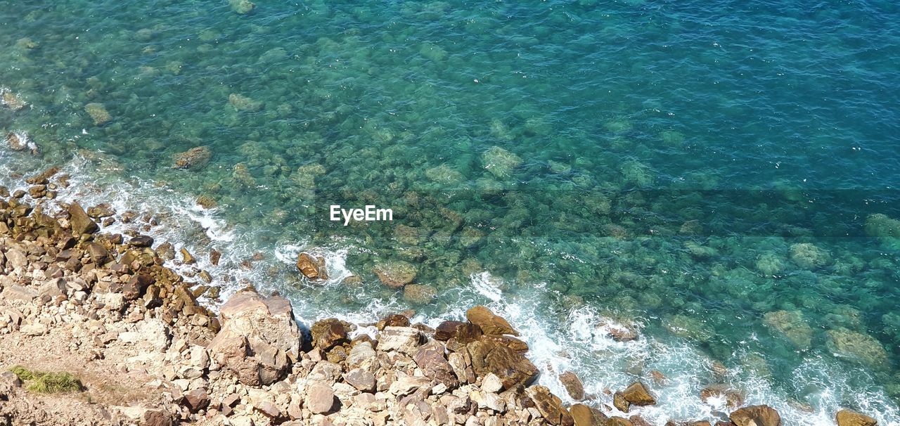 HIGH ANGLE VIEW OF ROCKS AT BEACH