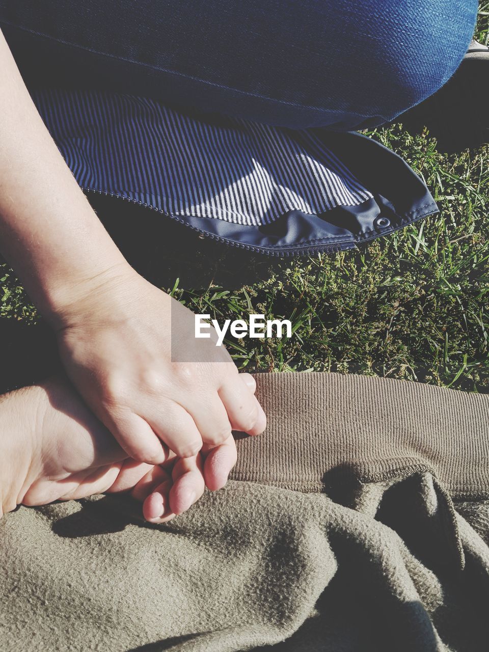 Cropped image of couple holding hands in sunny day