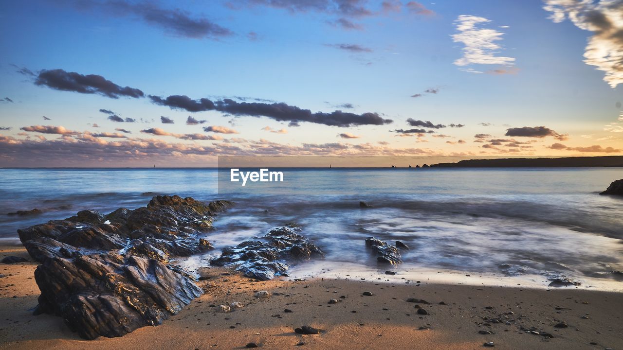 Scenic view of beach against sky during sunset