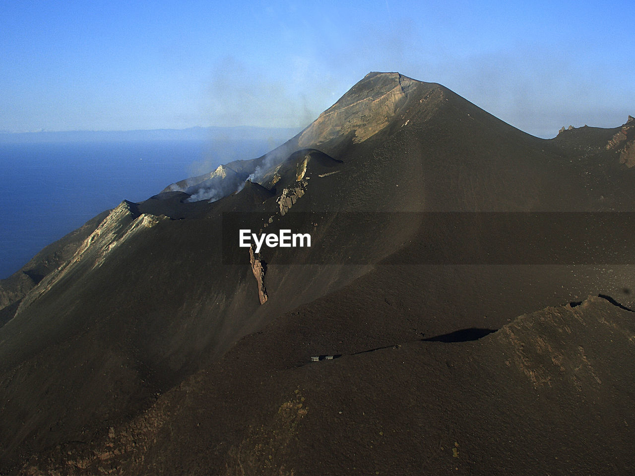 Stromboli volcano by sea against sky