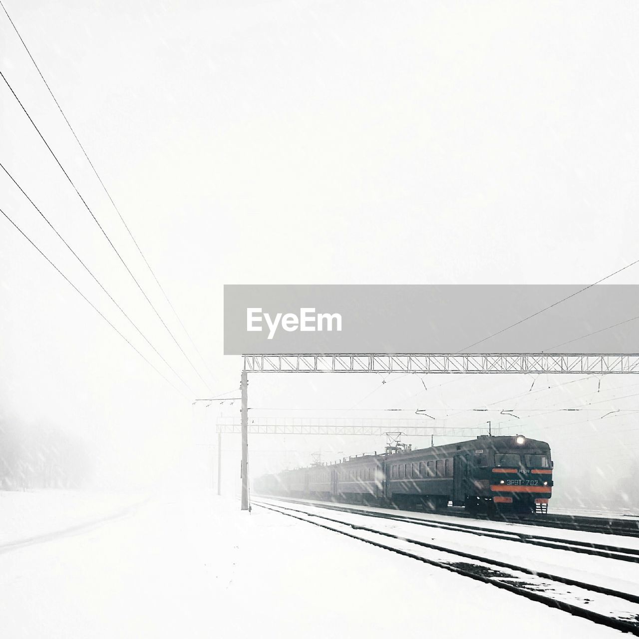 OVERHEAD CABLE CARS OVER SNOW AGAINST SKY