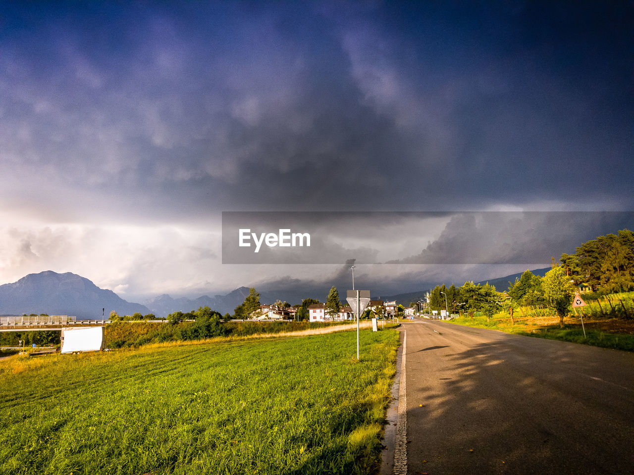 Road amidst field against sky