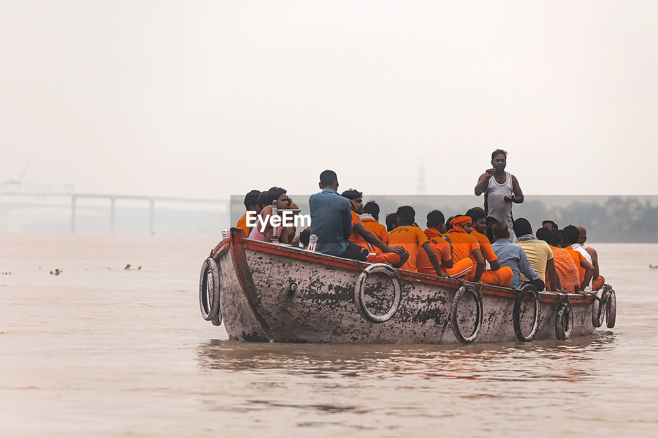 PEOPLE ON BOAT AGAINST CLEAR SKY