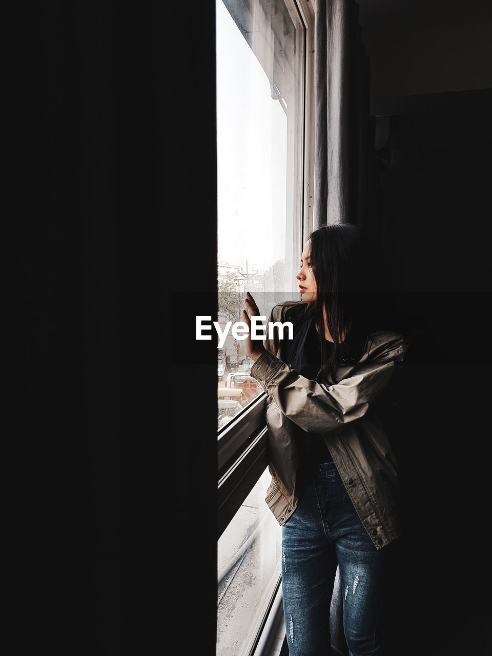 Woman standing by window at home