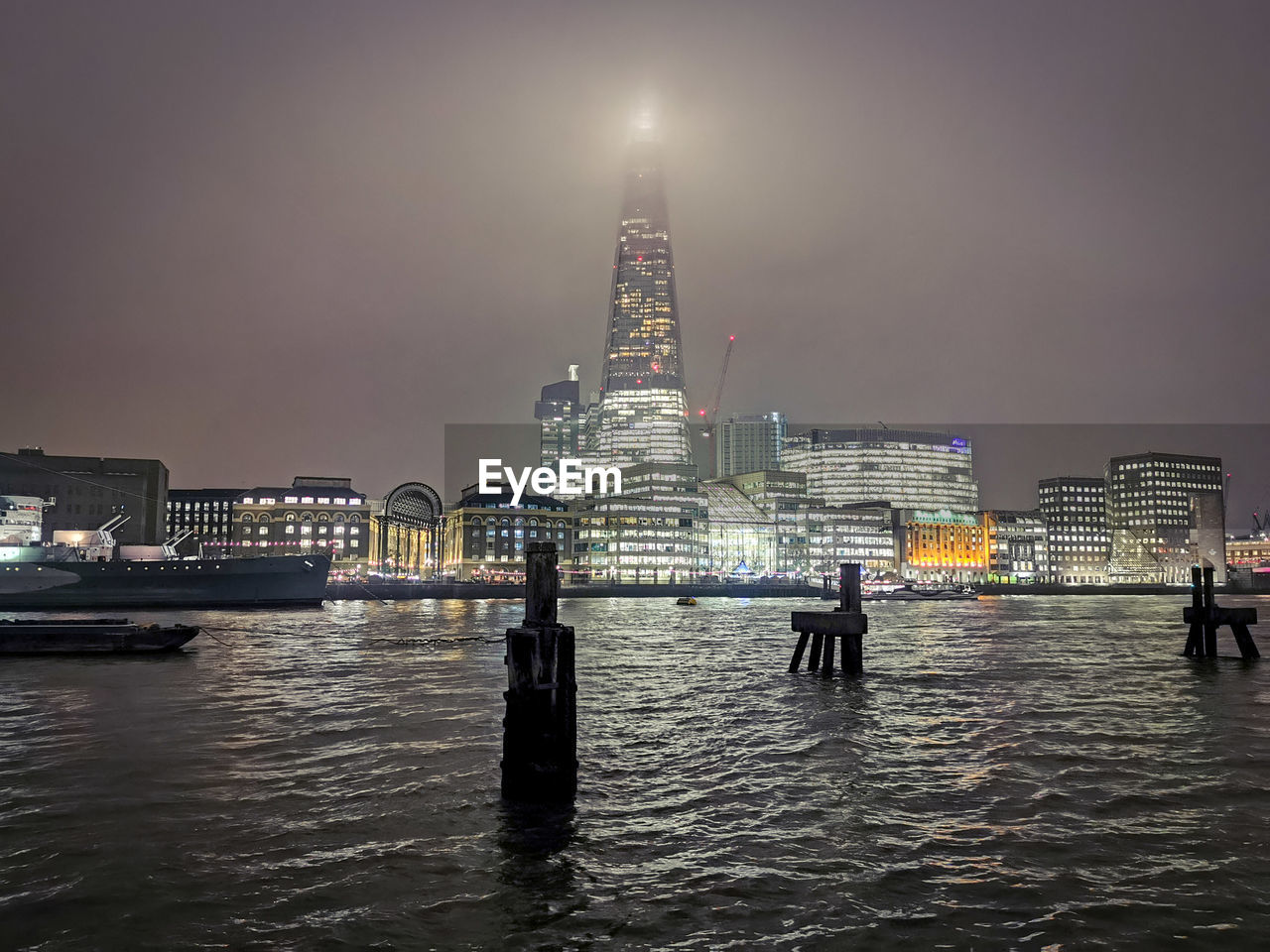 VIEW OF ILLUMINATED BUILDINGS AT WATERFRONT