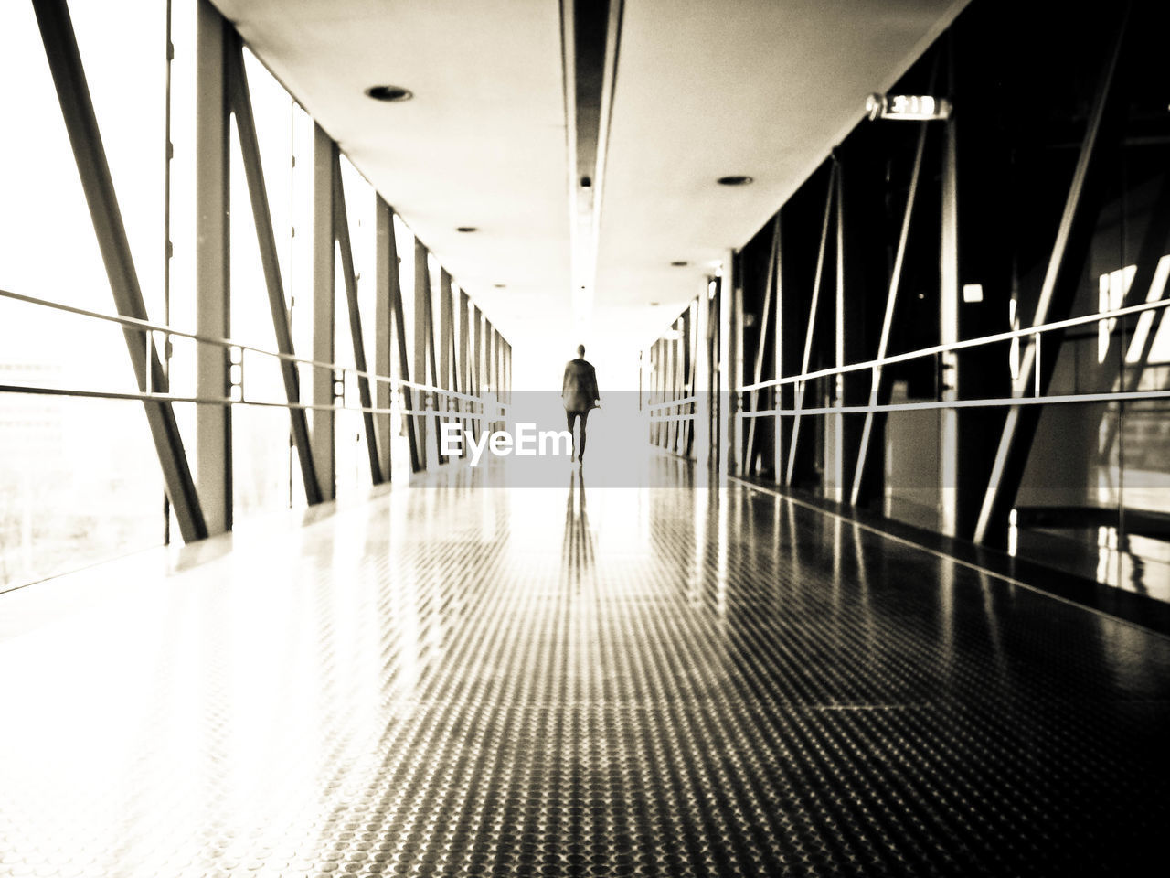 PEOPLE WALKING IN CORRIDOR OF BUILDING