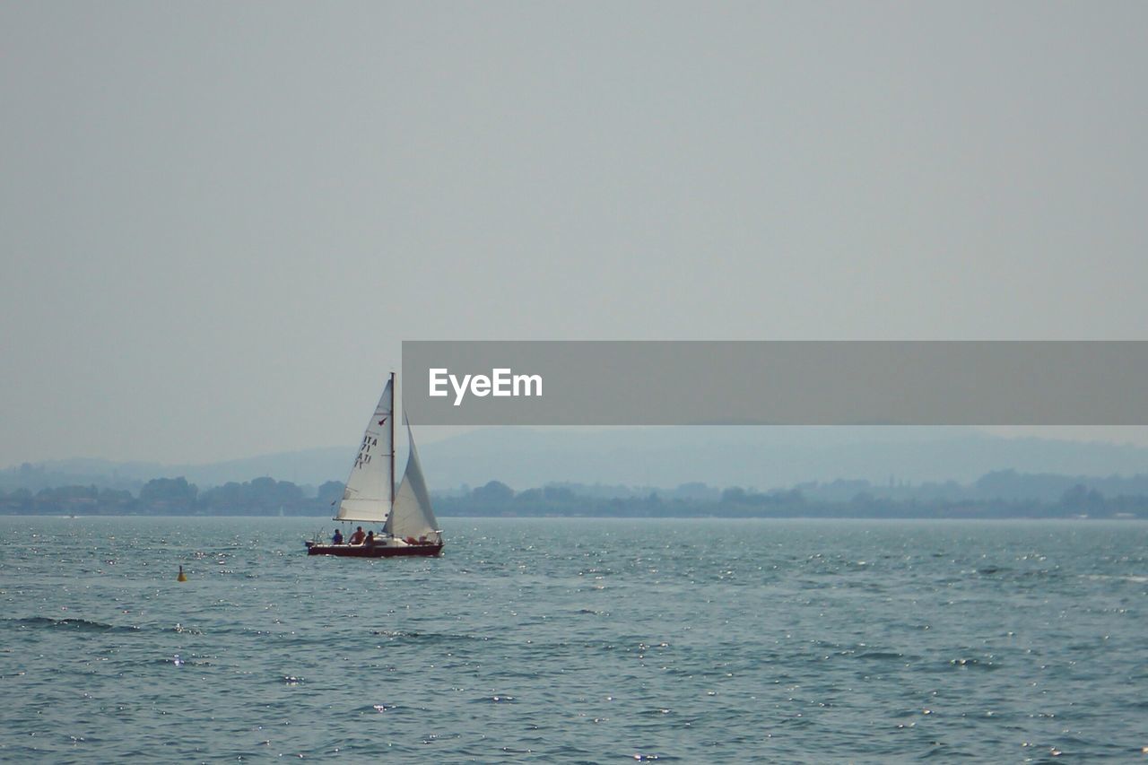 Sailboat in sea against sky