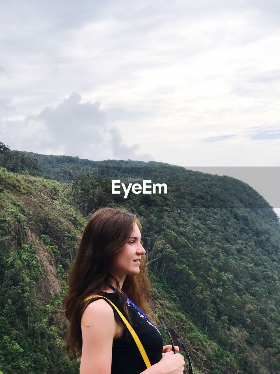 Side view of woman standing against mountains