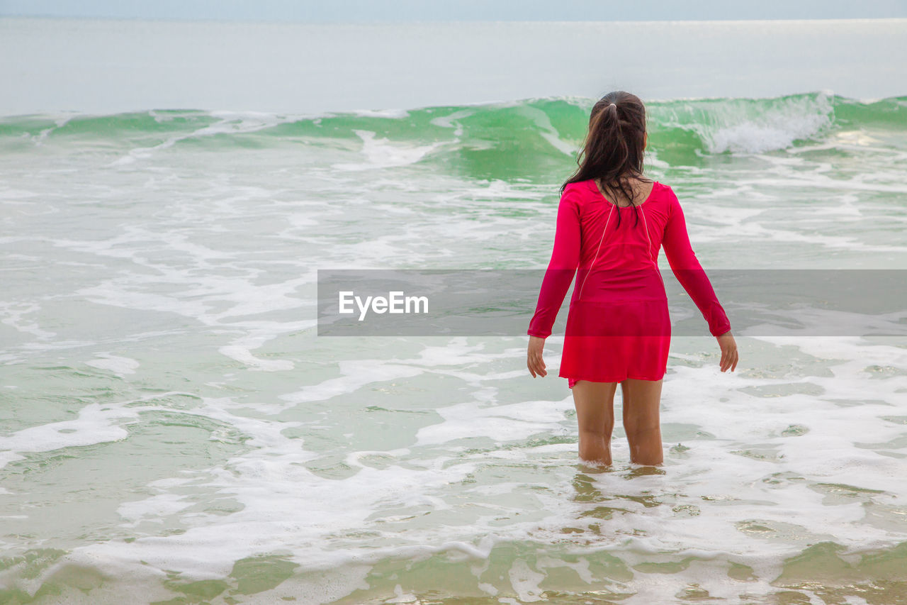 Rear view of girl standing in sea