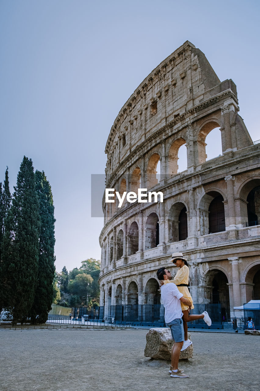 Couple standing against ancient built structure