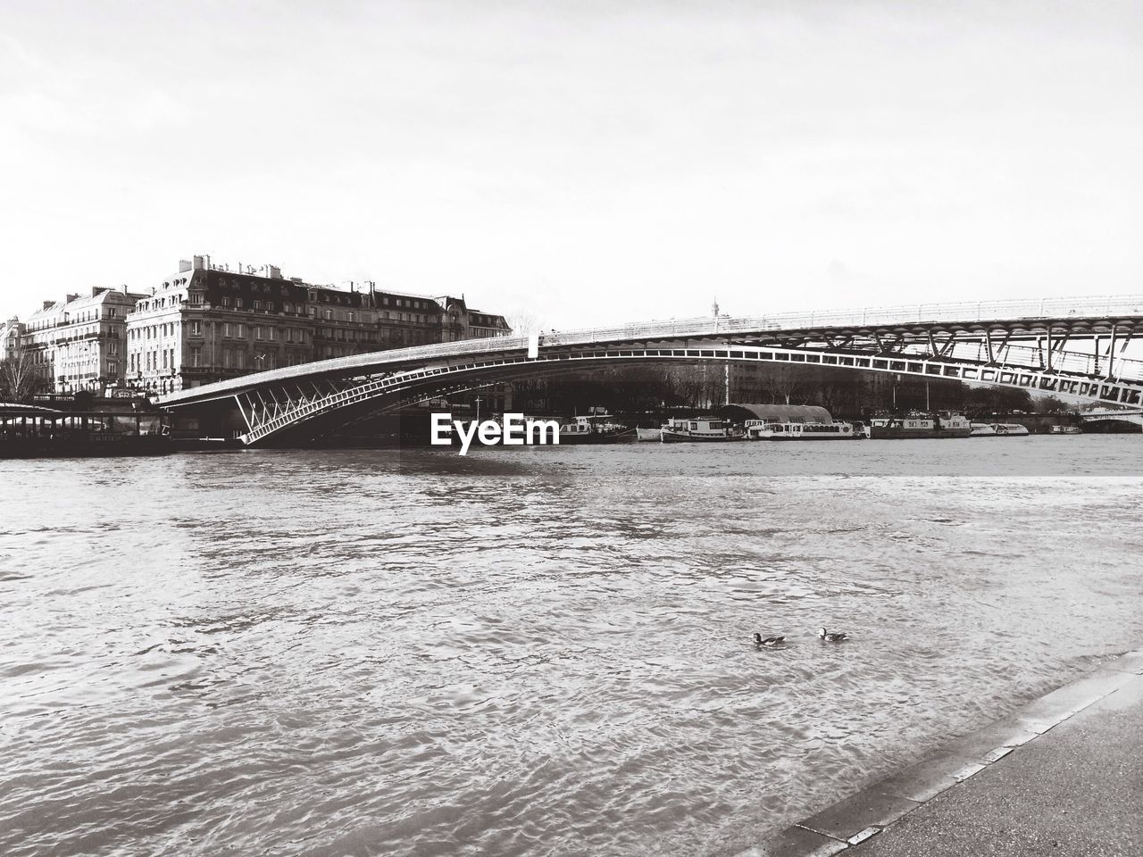 Bridge over river against clear sky in city