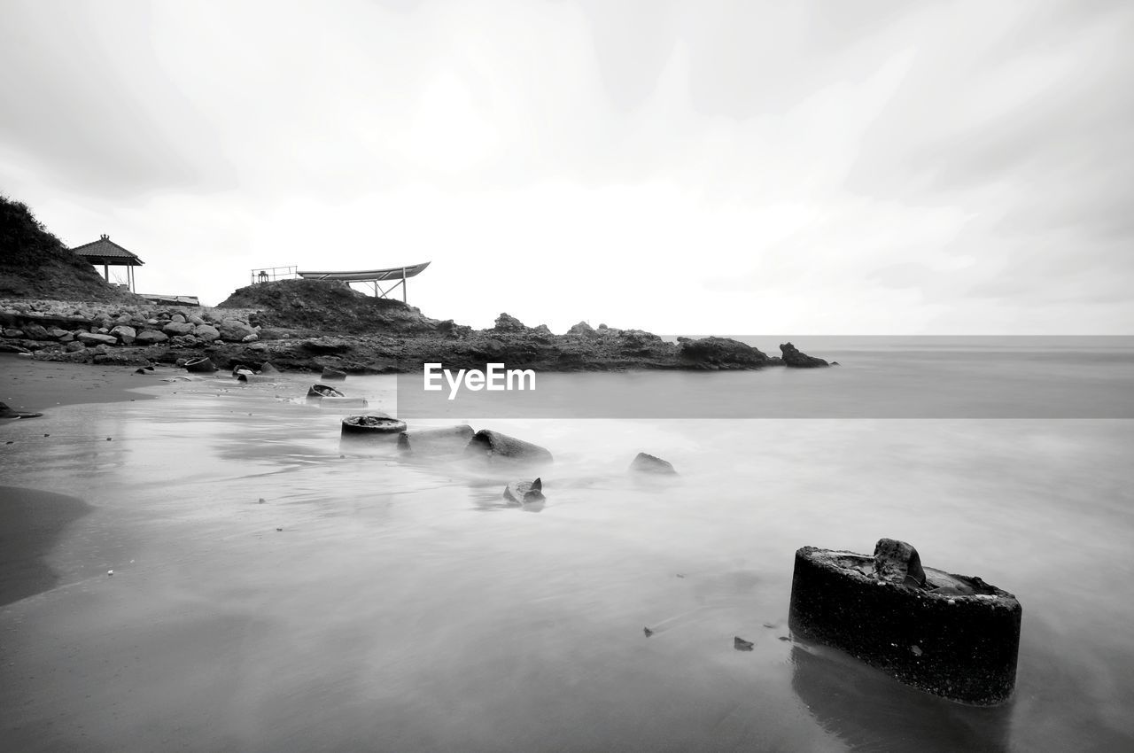 Scenic view of rocks on sea against sky