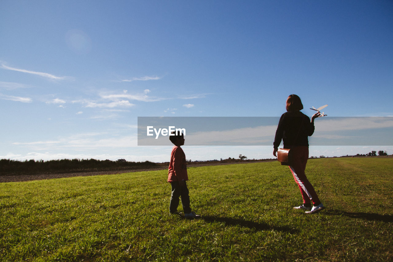 Mother and son on land against sky