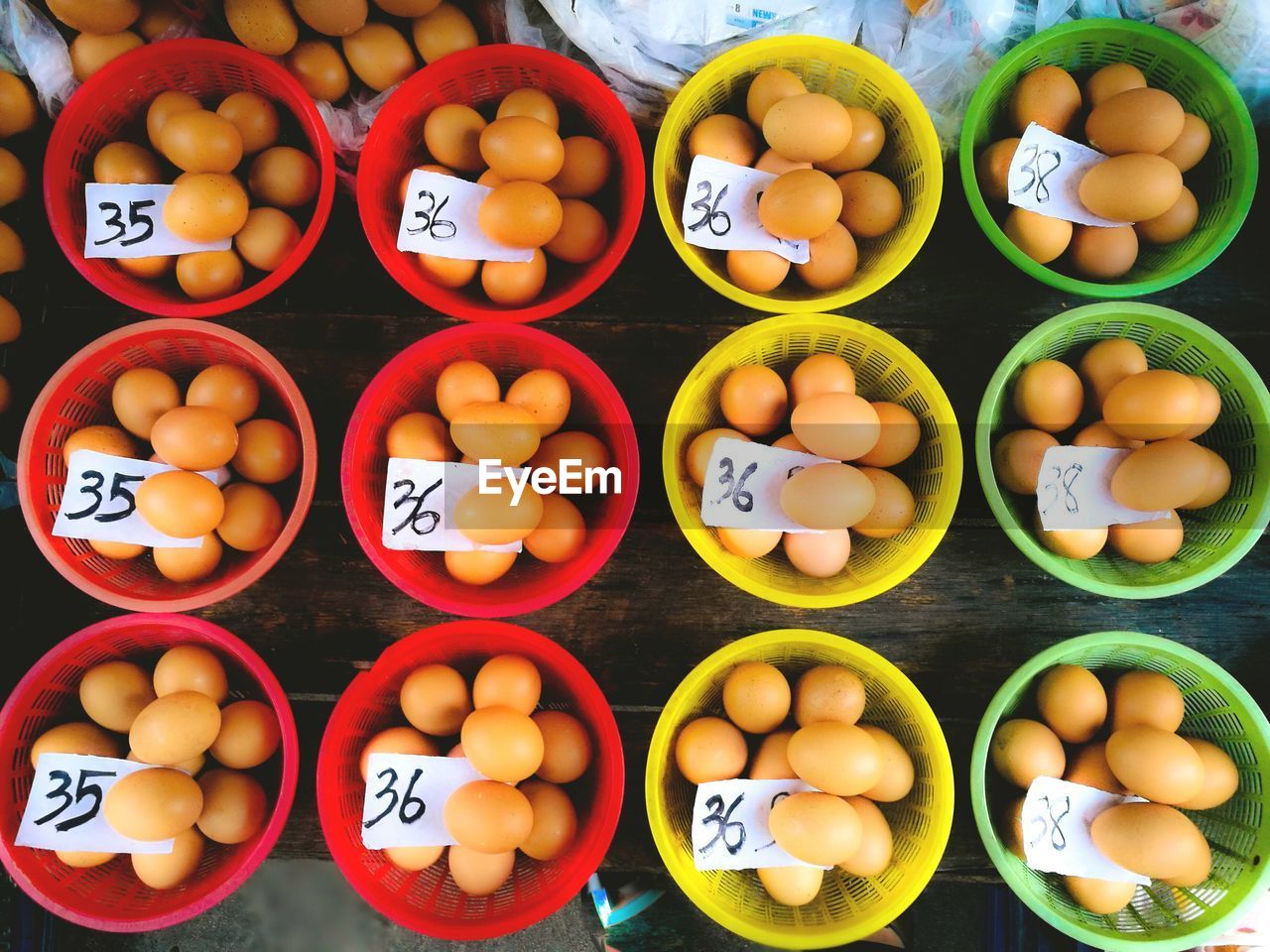 Directly above shot of eggs in bowls for sale on table at market