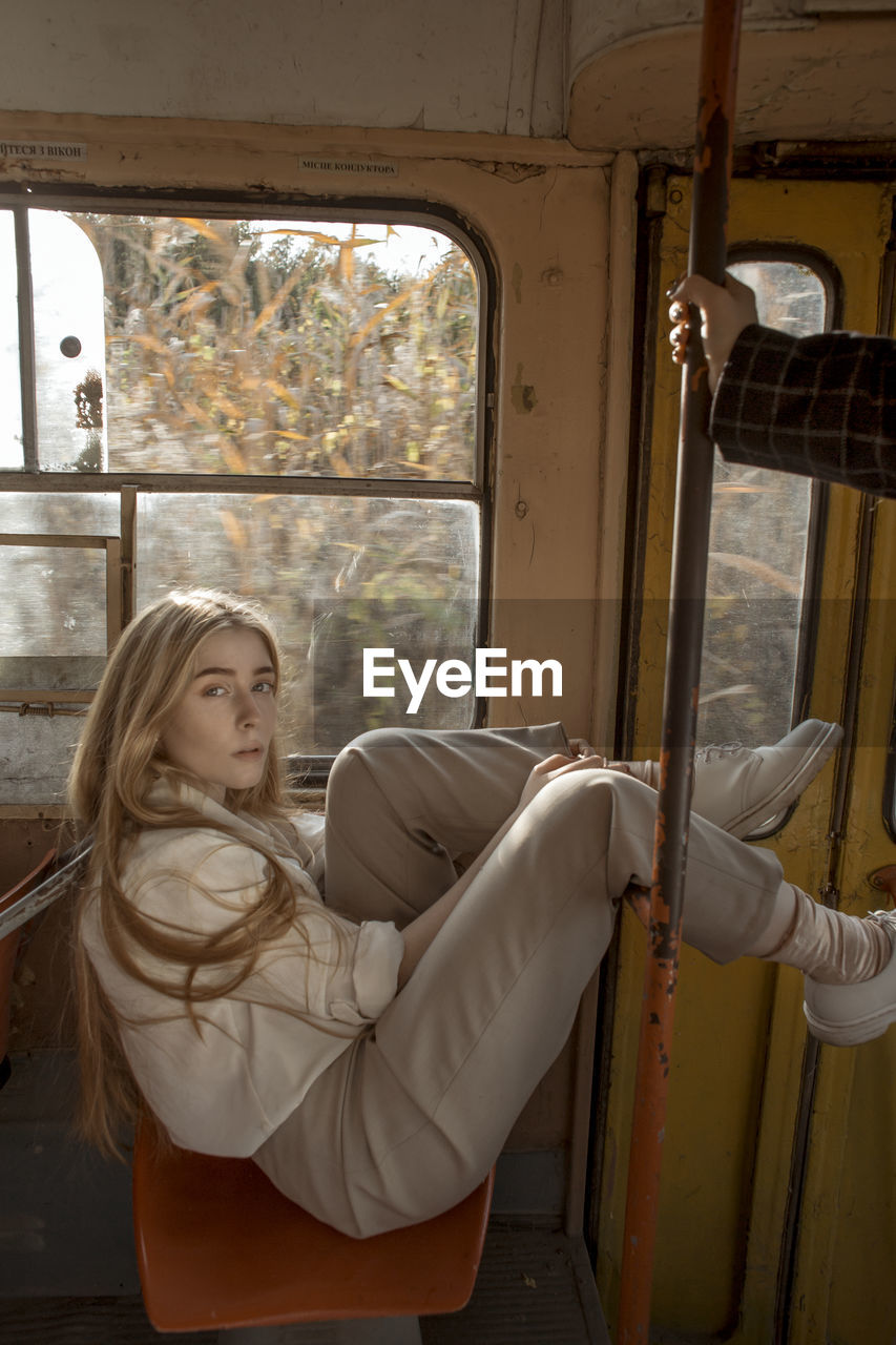 YOUNG WOMAN SITTING IN BUS