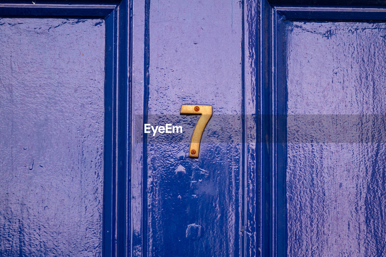 House number 7 on a blue wooden front door