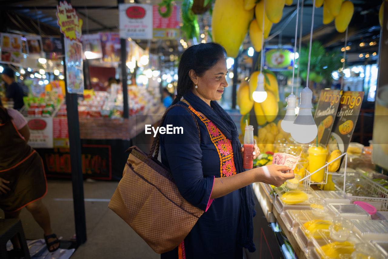 Woman standing in market at night