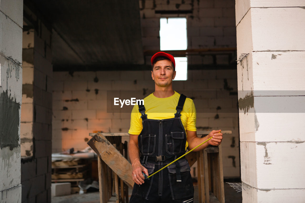 portrait of young man standing in abandoned house