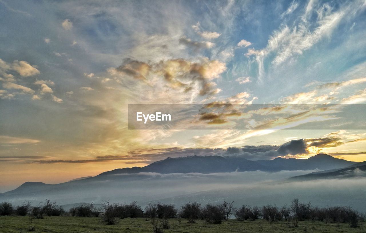 SCENIC VIEW OF LANDSCAPE AND MOUNTAINS AGAINST SKY