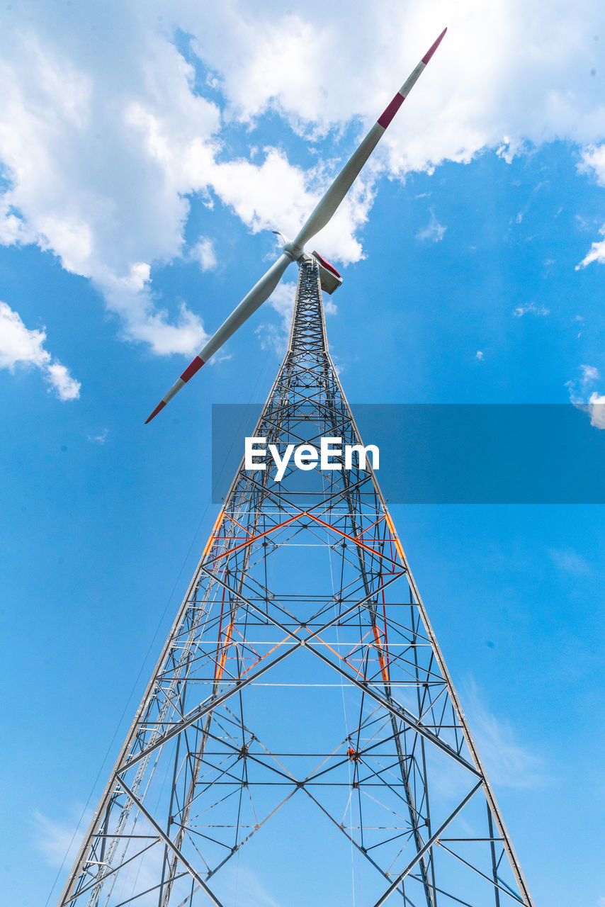 Low angle view of electricity wind mill against sky