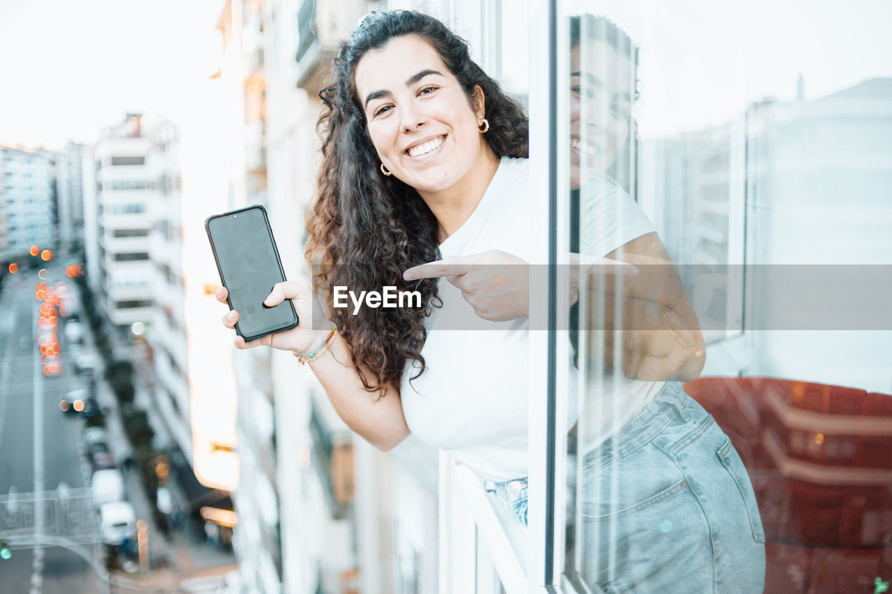 Young woman showing mobile phone