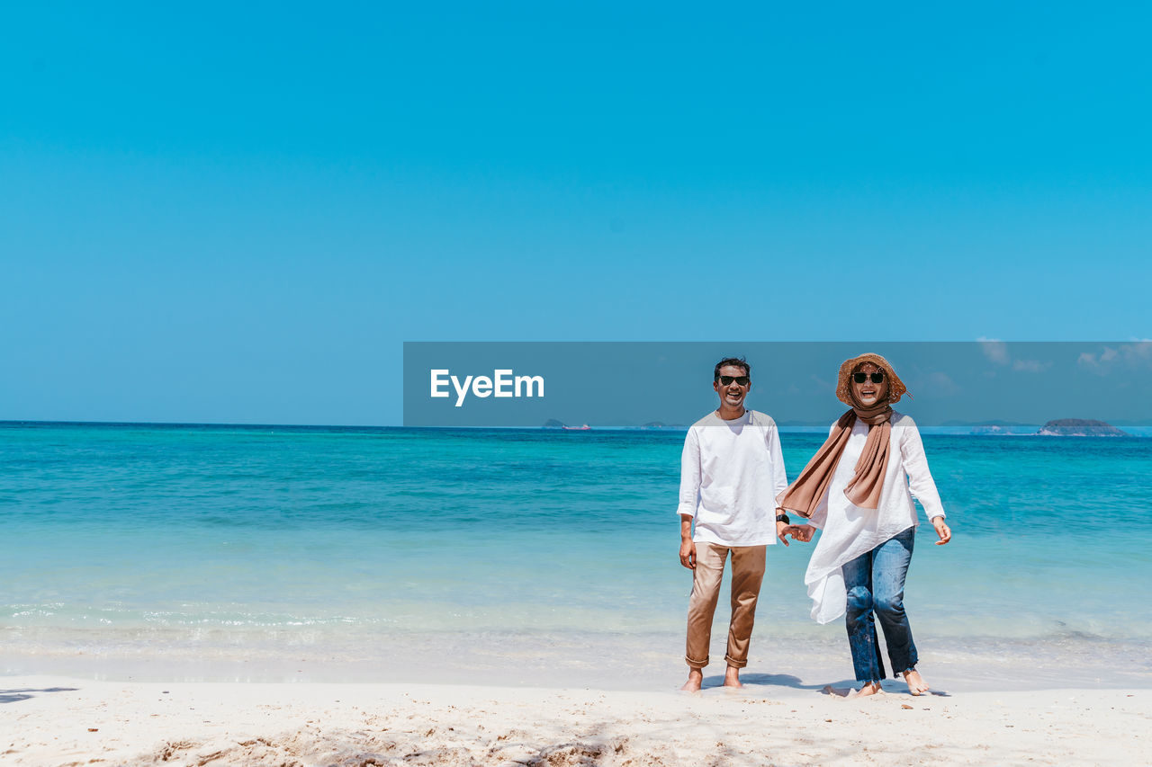 Portrait of couple standing at beach 