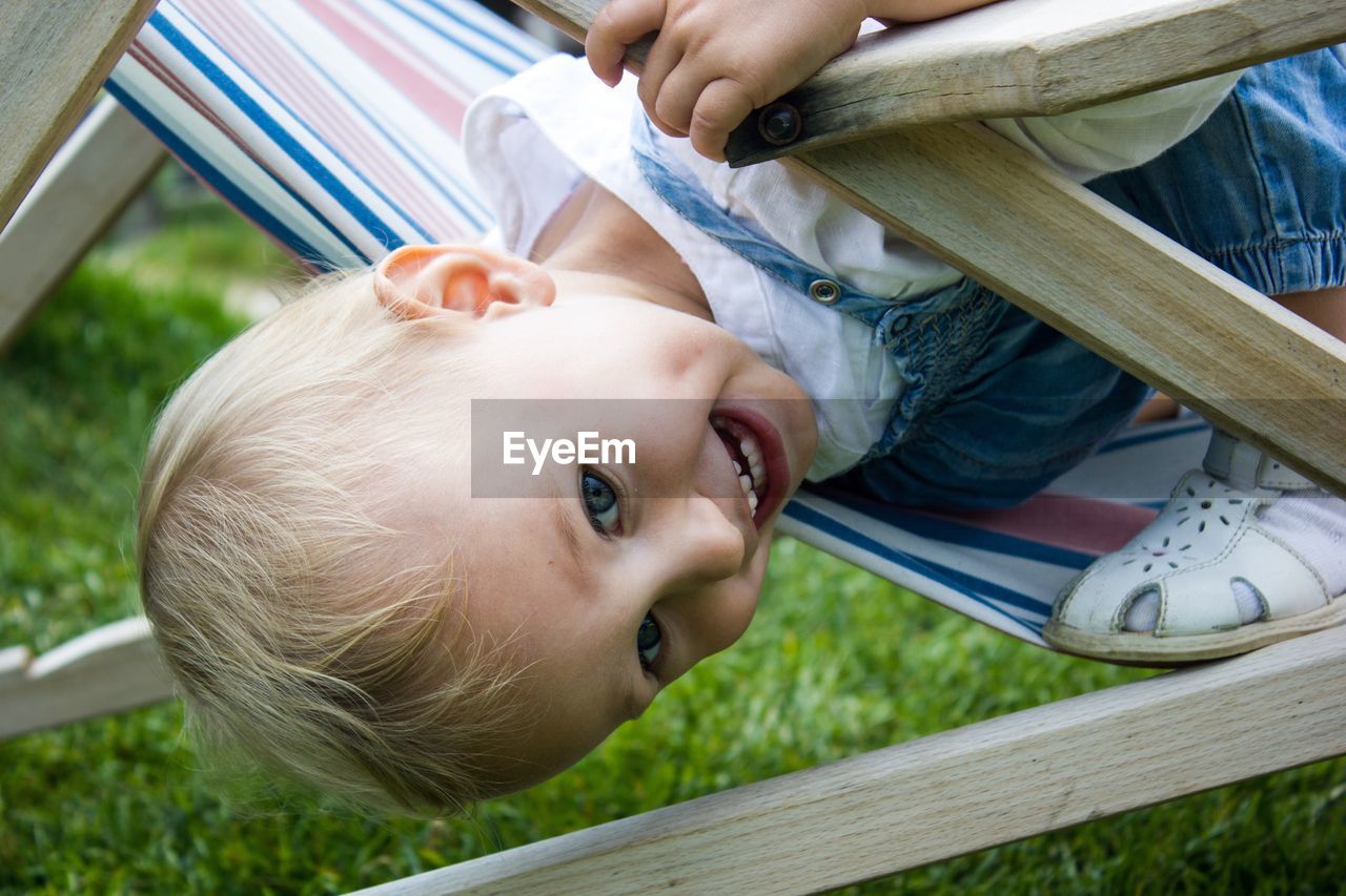 Close-up of boy playing on folding chair