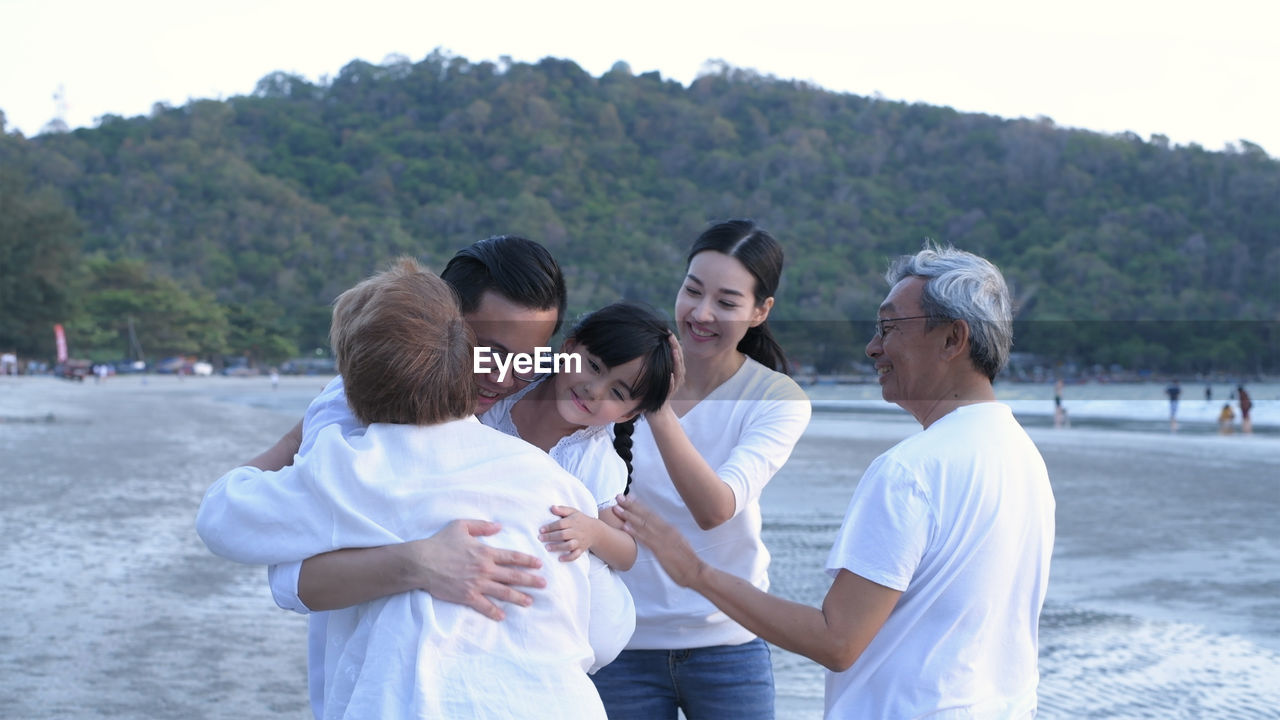 GROUP OF FRIENDS STANDING ON SHORE