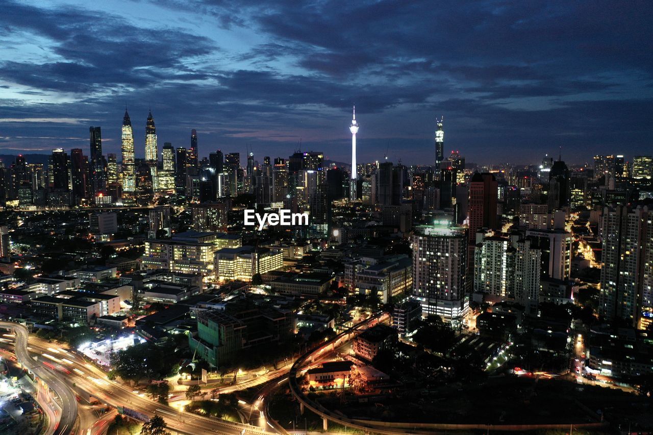 Illuminated cityscape against sky at night