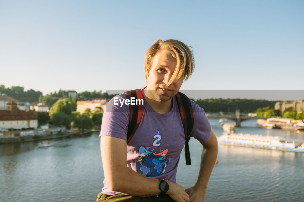 Portrait of young man against river