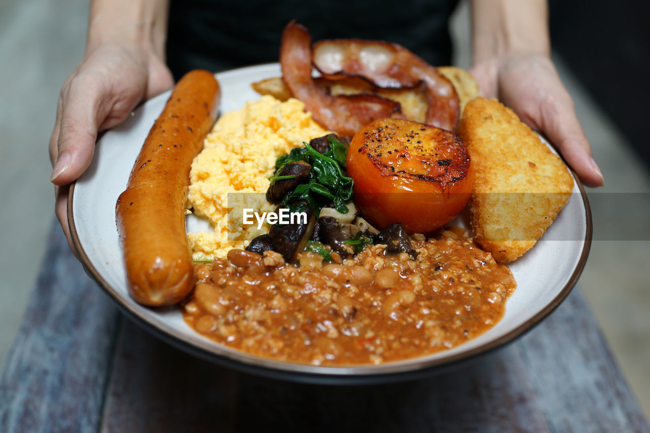 Cropped hands of person holding food served in plate