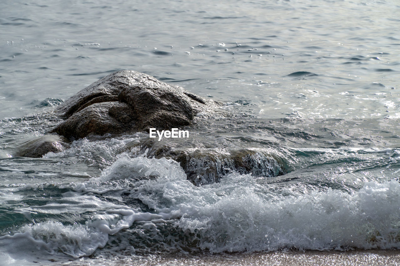 SEA WAVES SPLASHING IN A RIPPLED WATER