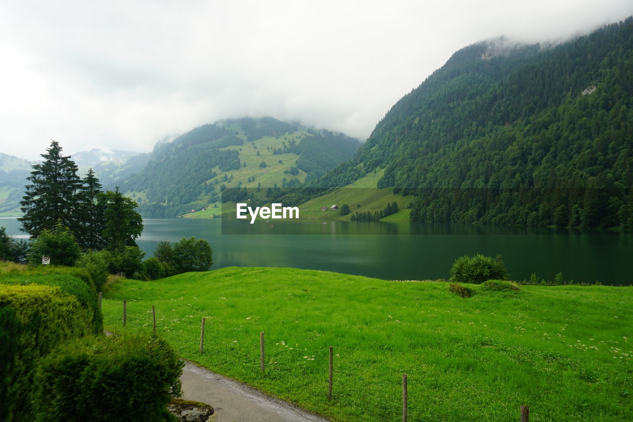 Scenic view of lake by mountains against sky