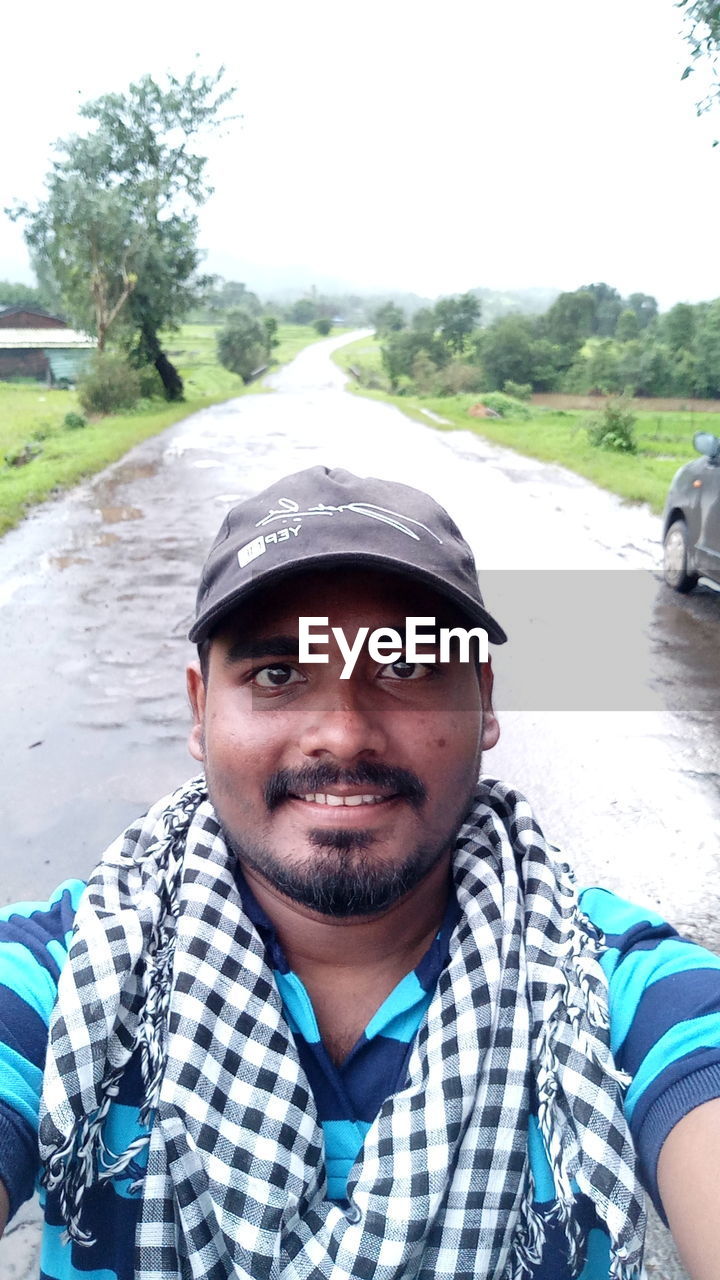 PORTRAIT OF MAN STANDING AGAINST BLUE SKY