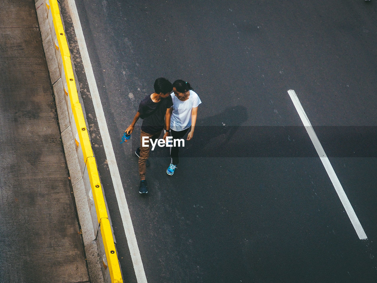 High angle view of couple walking on road in city