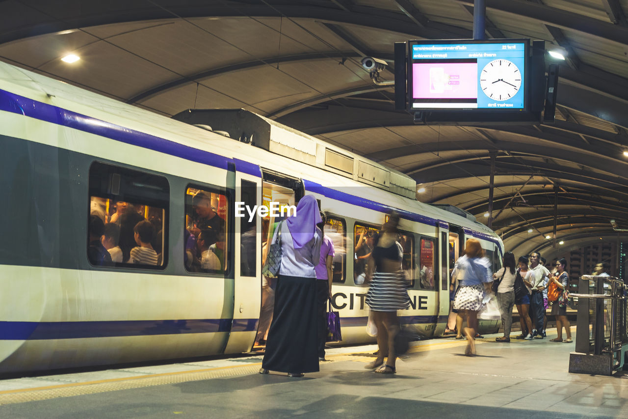 PEOPLE WAITING ON RAILROAD STATION PLATFORM