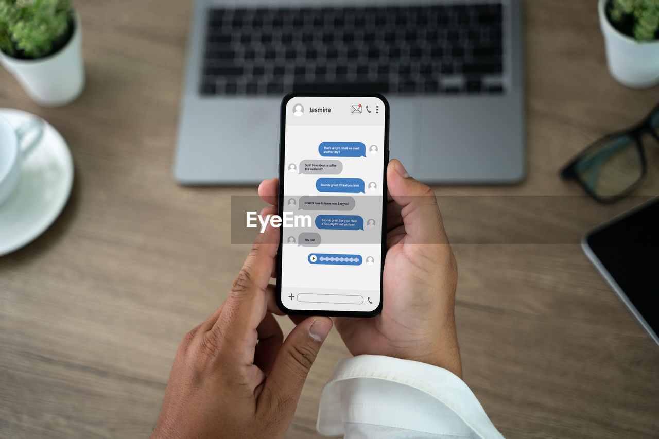wireless technology, technology, communication, portable information device, smartphone, mobile phone, computer, internet, tableware, adult, hand, business, table, computer network, portability, telephone, one person, business finance and industry, gadget, convenience, mobile app, indoors, high angle view, furniture, digital tablet, desk, screen, lifestyles, men, place of work, office, plate, using computer, laptop, food and drink, home interior, finance, working, holding, close-up, finance and economy, cup, young adult, houseplant