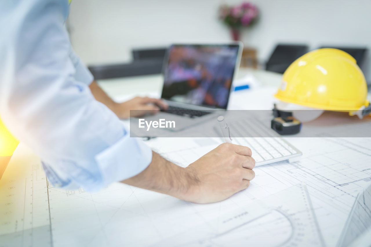 MAN WORKING ON TABLE IN OFFICE