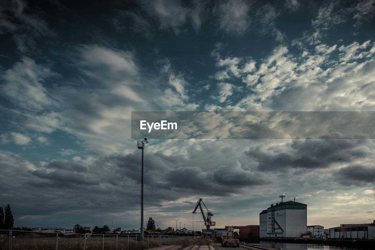 View of factory against cloudy sky during sunset