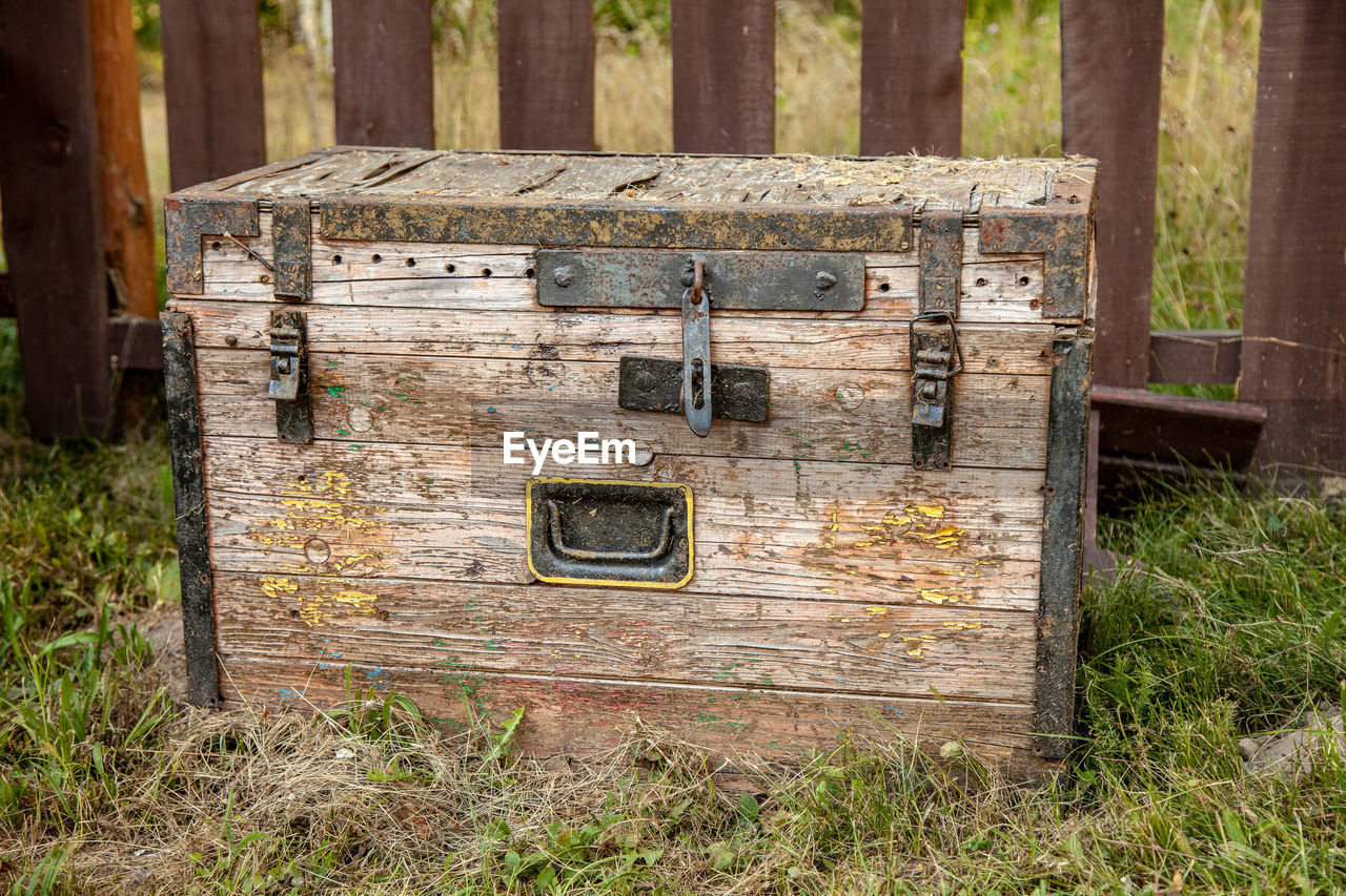 Old wooden storage chest on the grass.