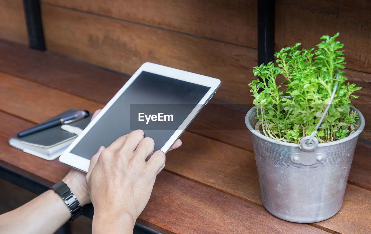 High angle view of person using mobile phone on table