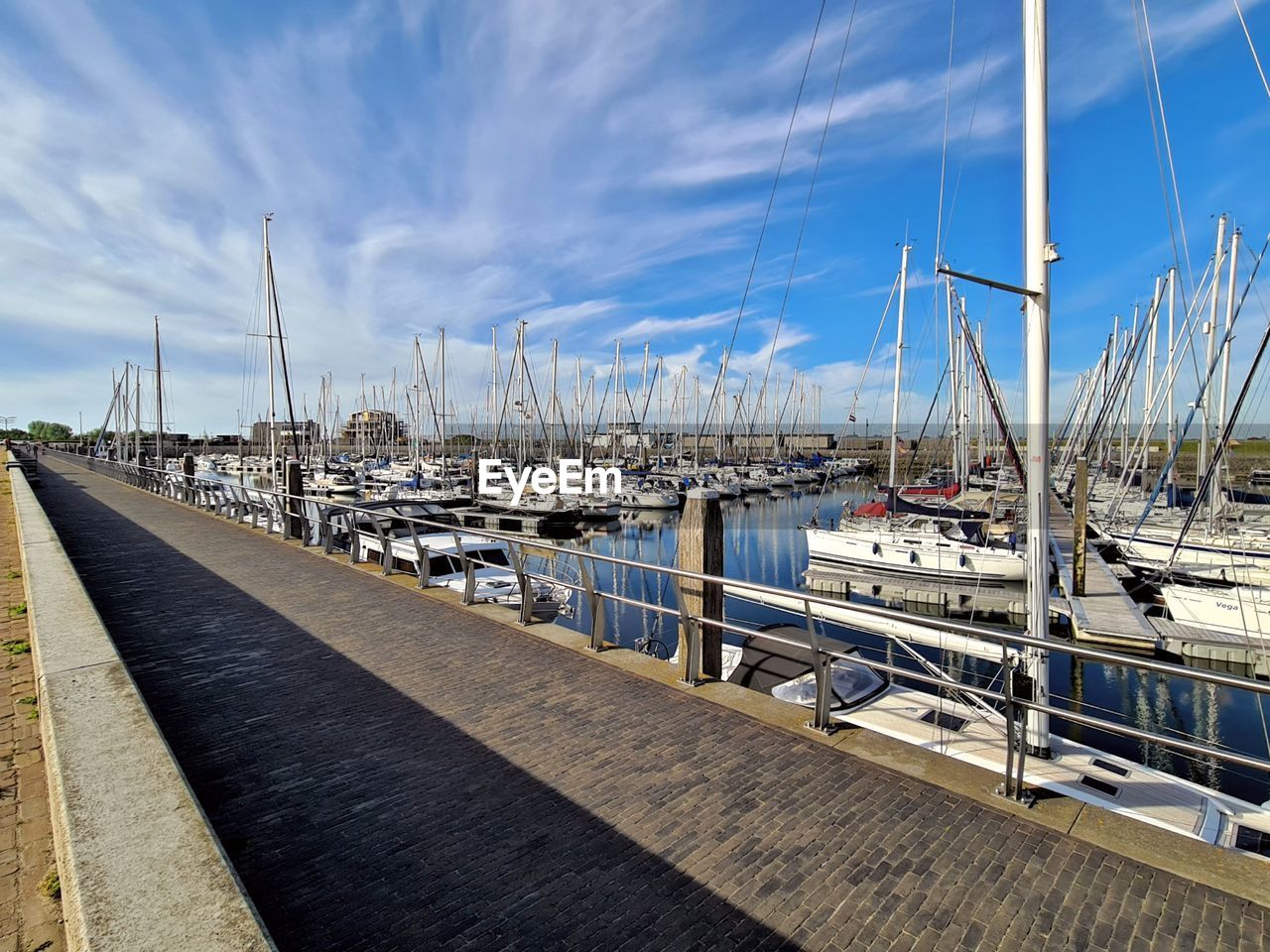 Sailboats moored at harbor