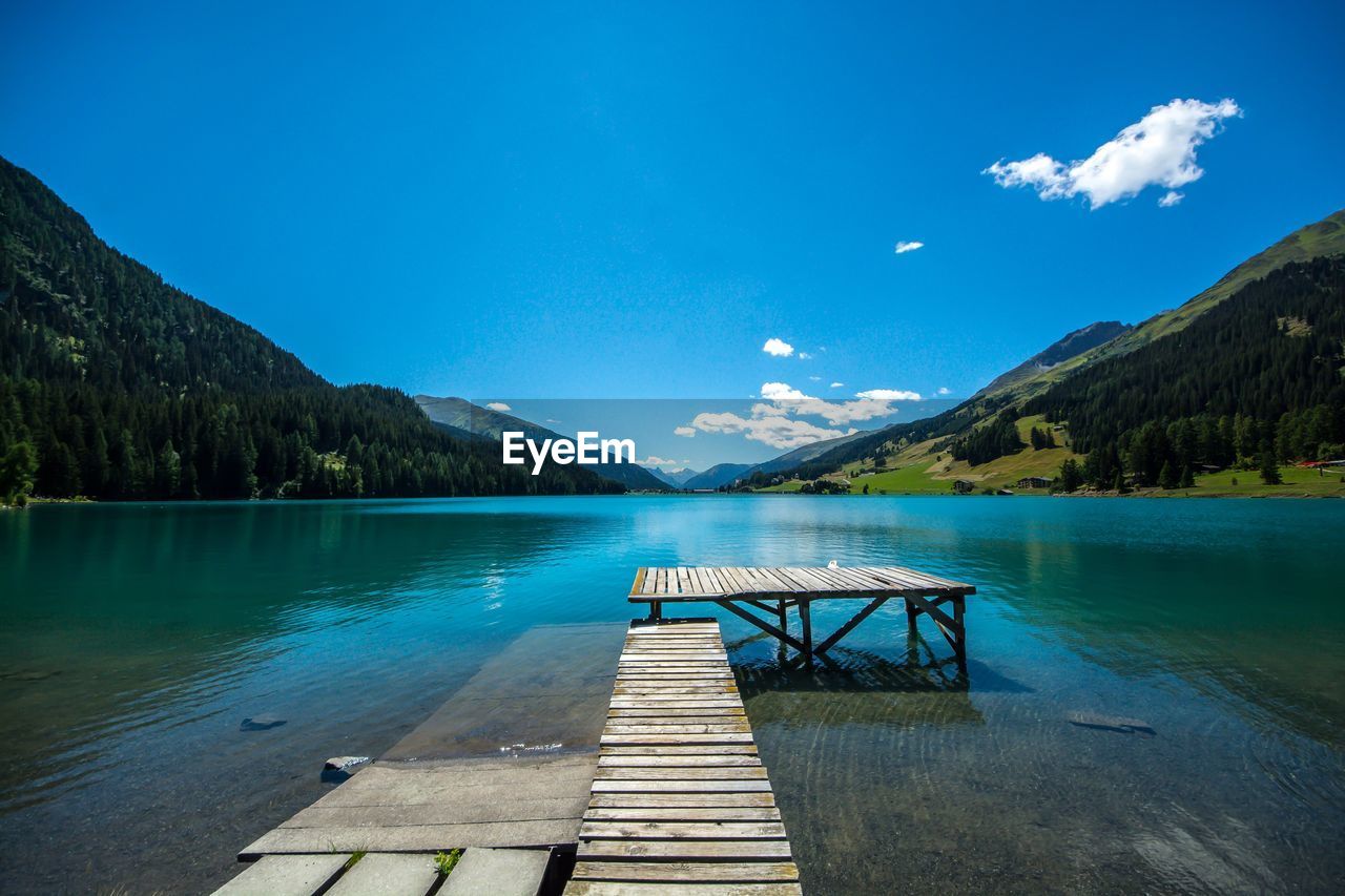 Pier over lake against blue sky