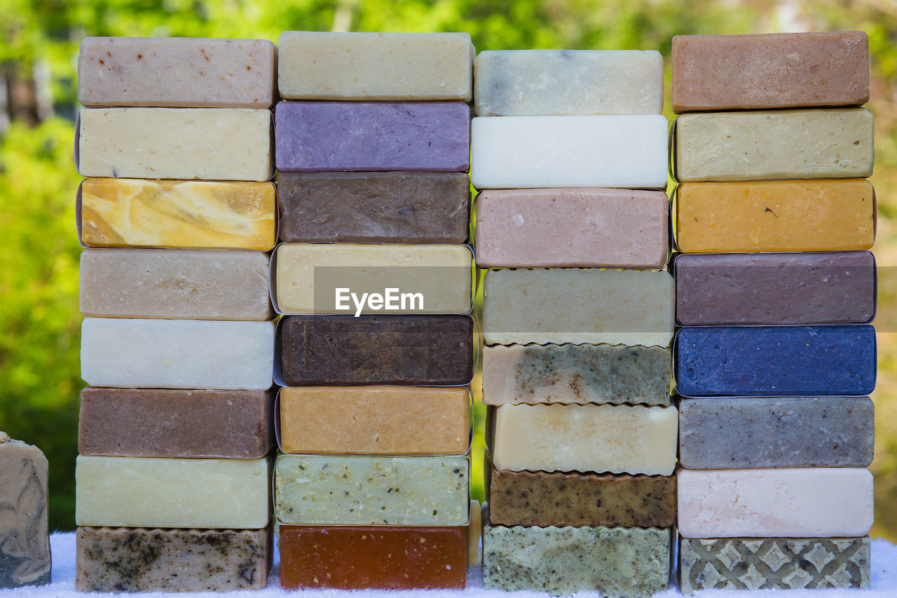 Close-up of multi colored organic soaps stacked on table outdoors