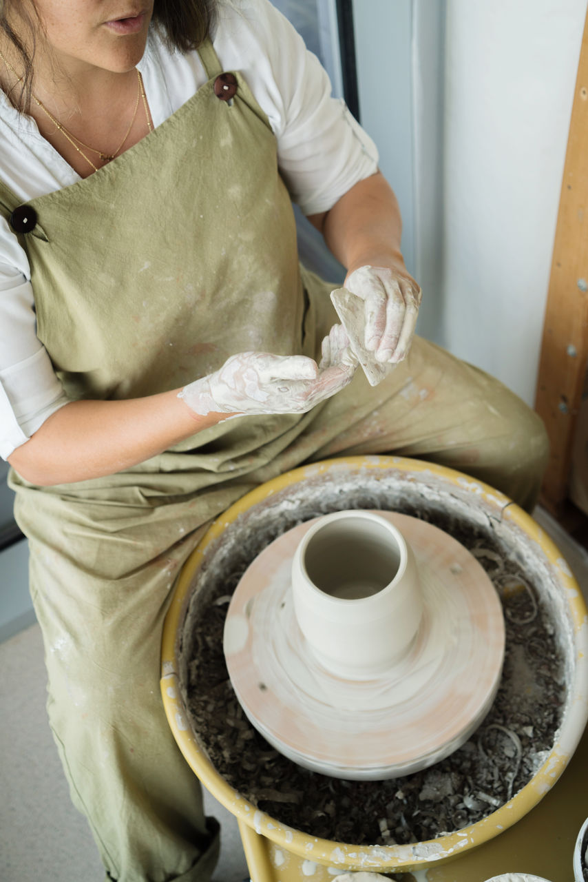 Woman making pottery on the wheel