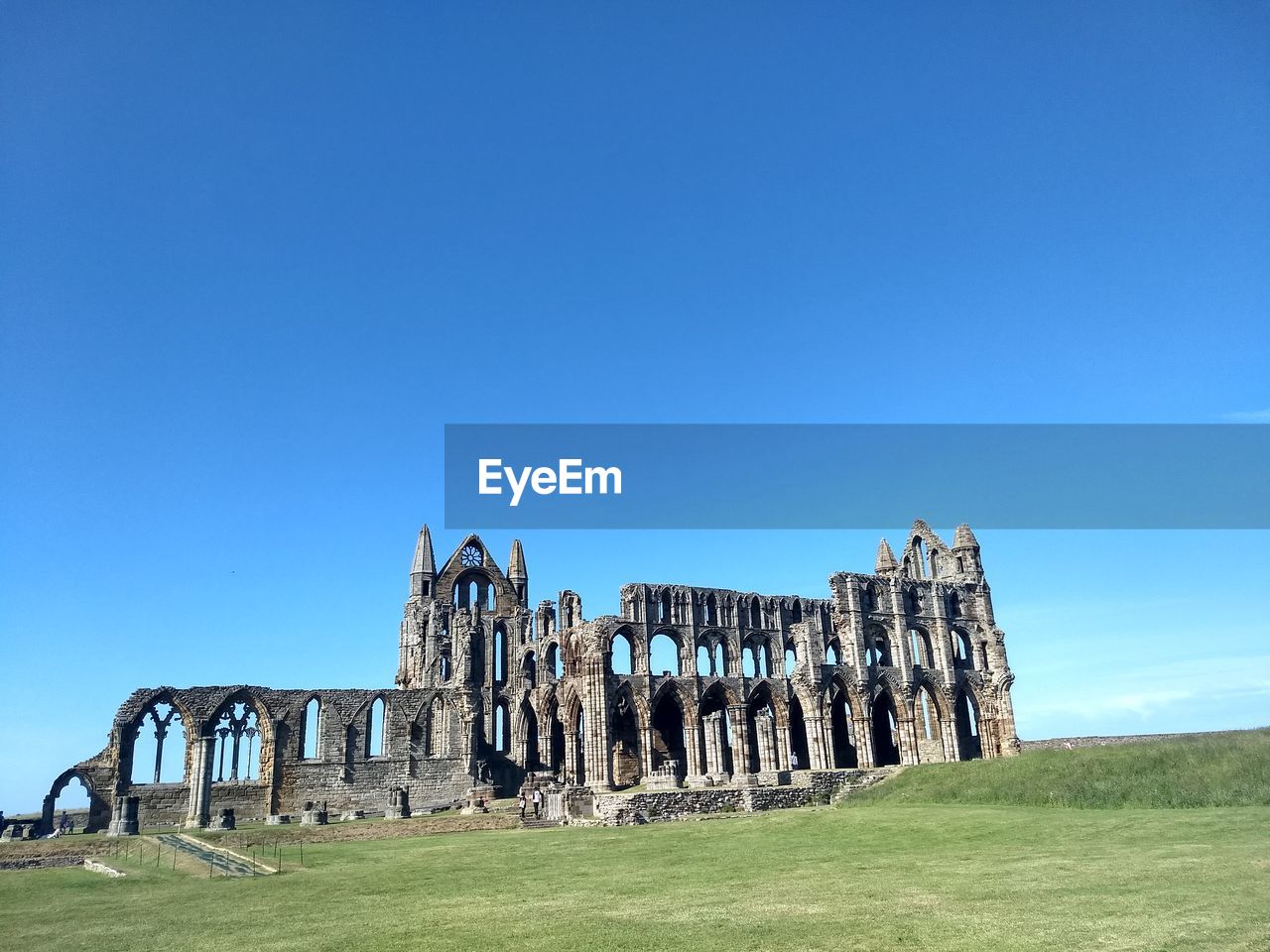 Old ruin on land against blue sky