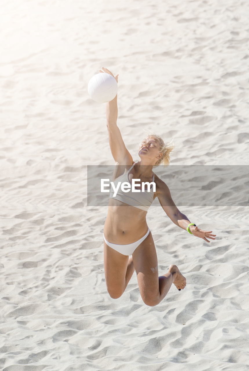 Woman with arms raised on beach