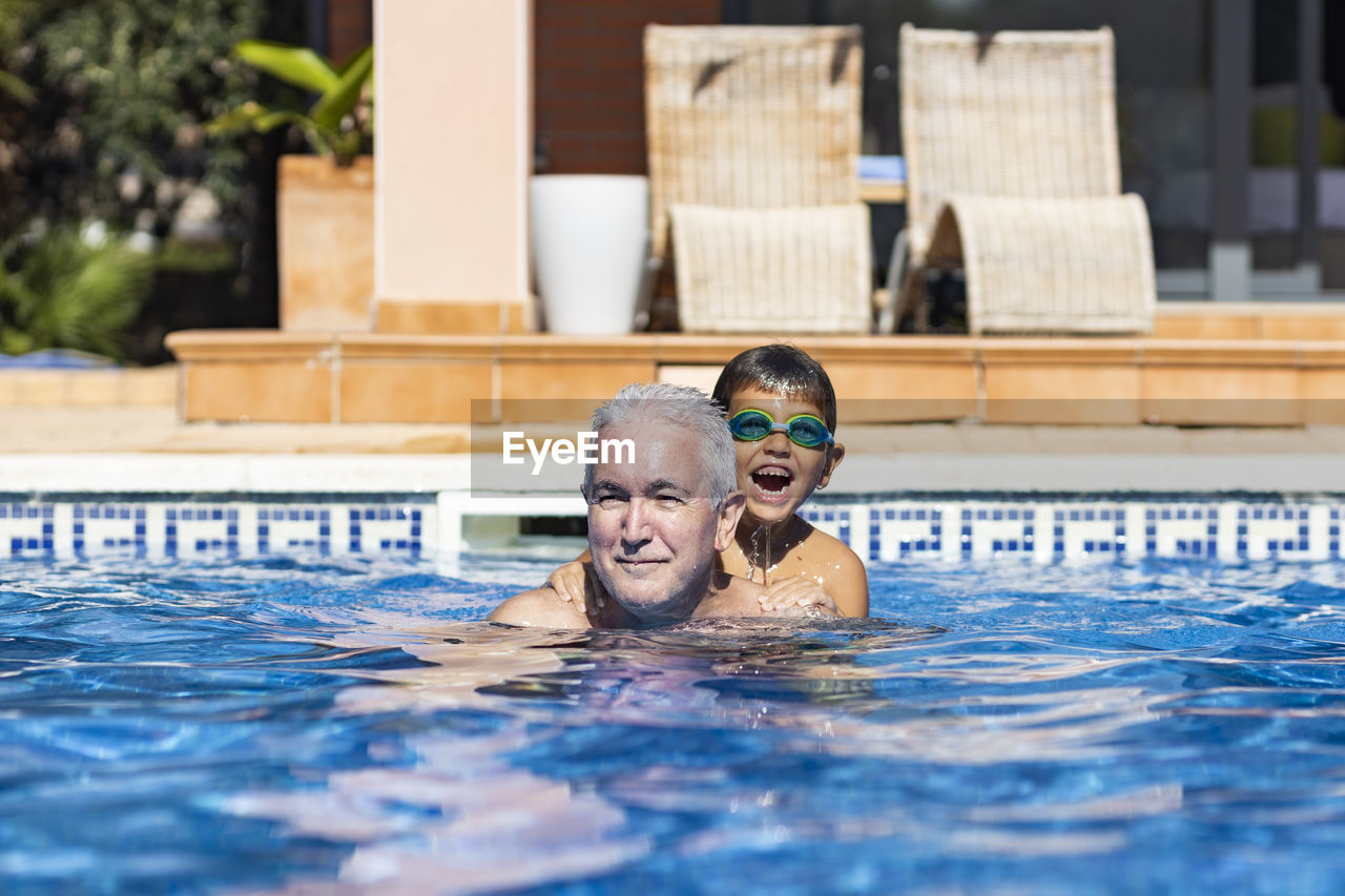 PORTRAIT OF MAN WITH SWIMMING POOL IN WATER