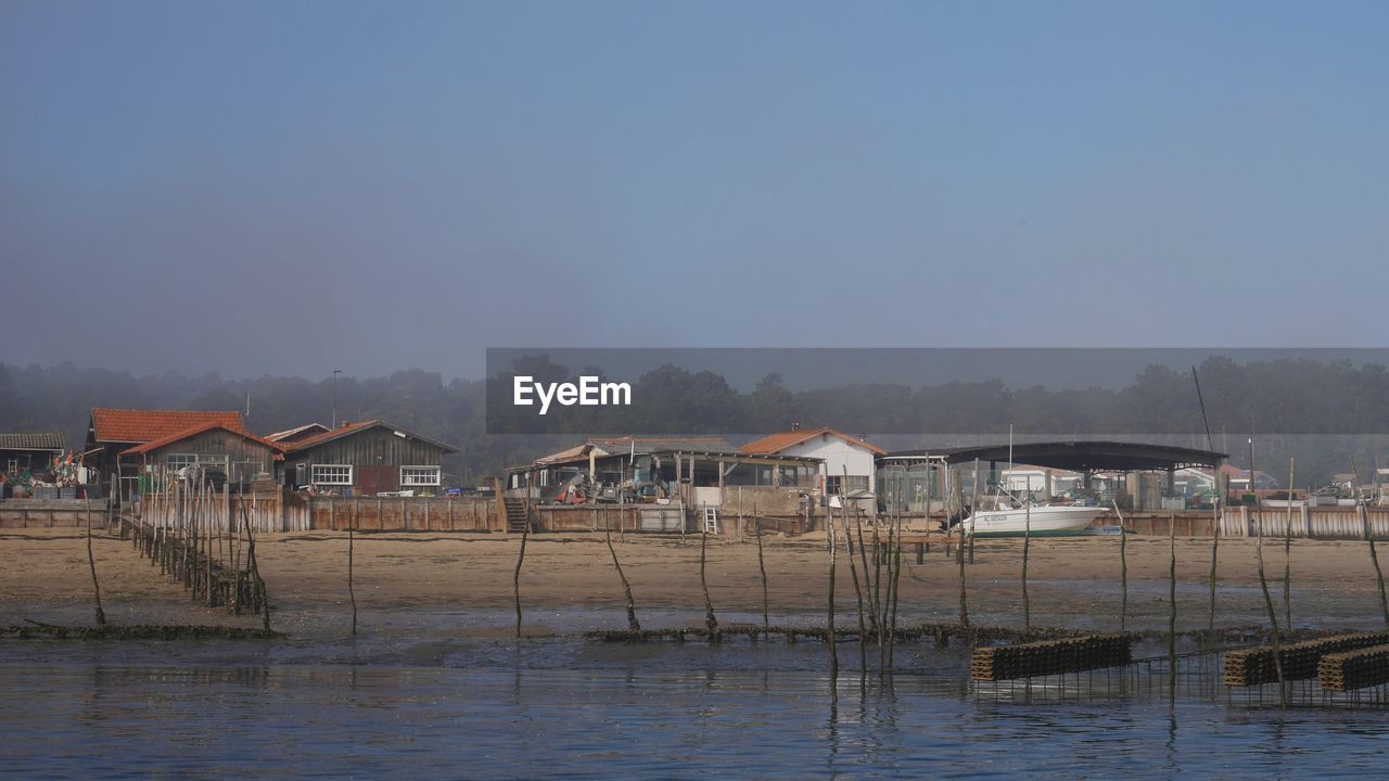 PIER OVER SEA AGAINST HOUSES