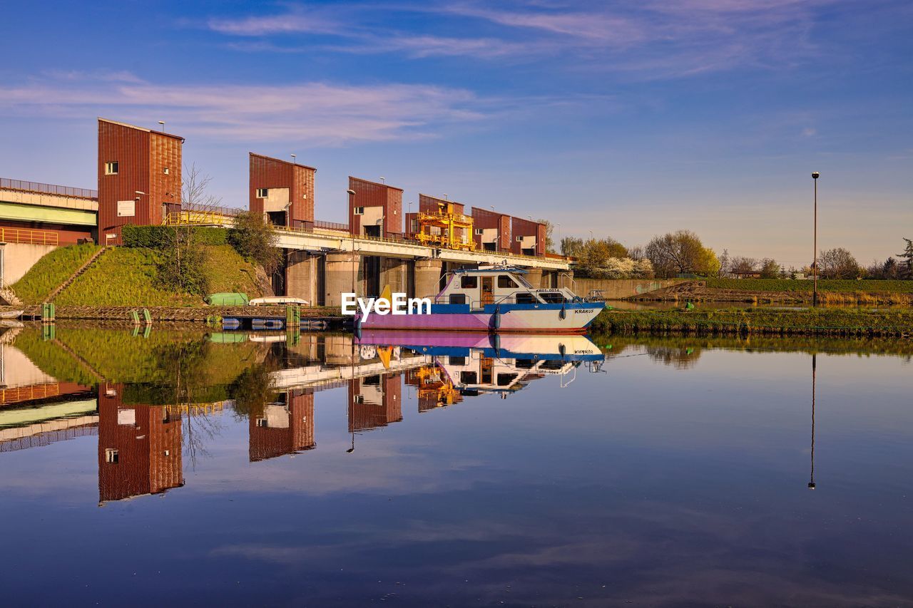 SCENIC VIEW OF LAKE BY BUILDING AGAINST SKY